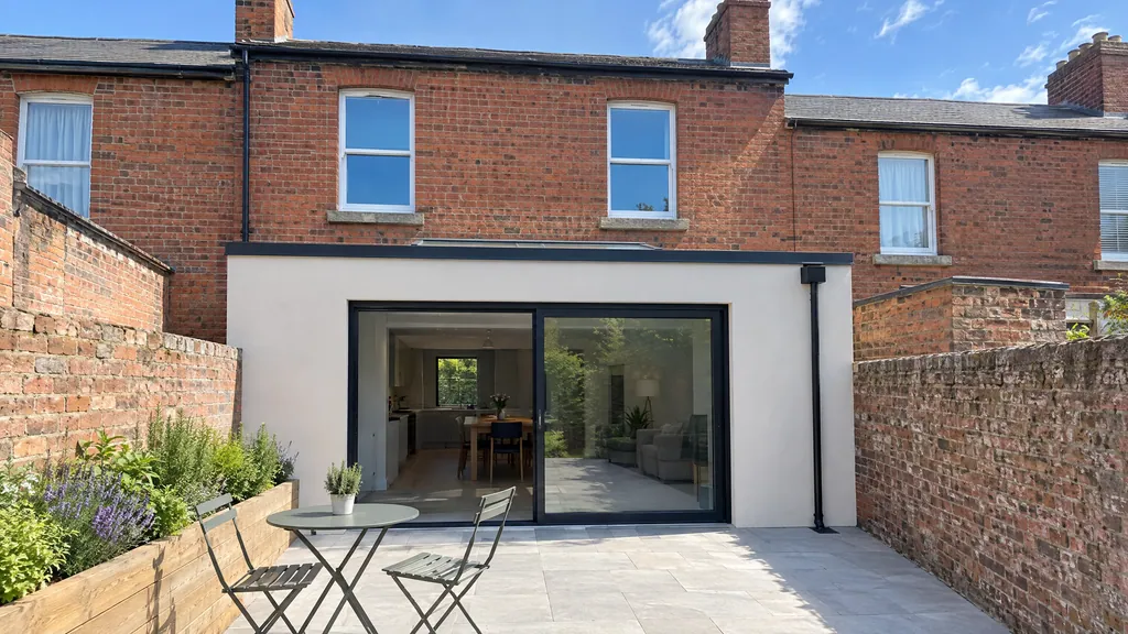 Compact 20m² single-storey rear extension with a flat roof and rooflight on a red-brick terraced house in Dublin.