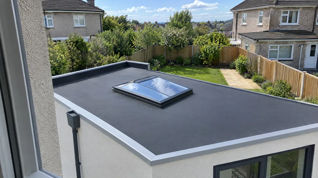 EPDM rubber flat roof extension on a Dublin semi, seen from the first-floor window, with a roof lantern and parapet outlet.