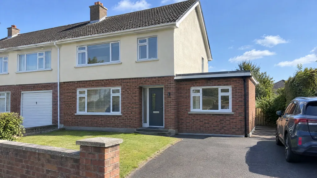 A 1970s Dublin semi-detached house where the garage conversion was exempt from planning permission, with a matching brick infill and white window where the garage door was.