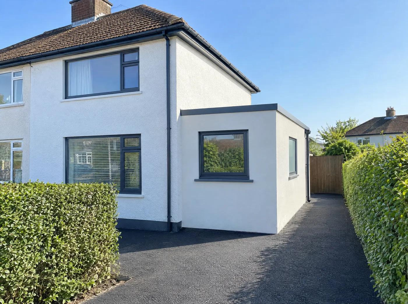 Single-storey side extension with a flat roof beside a semi-detached house