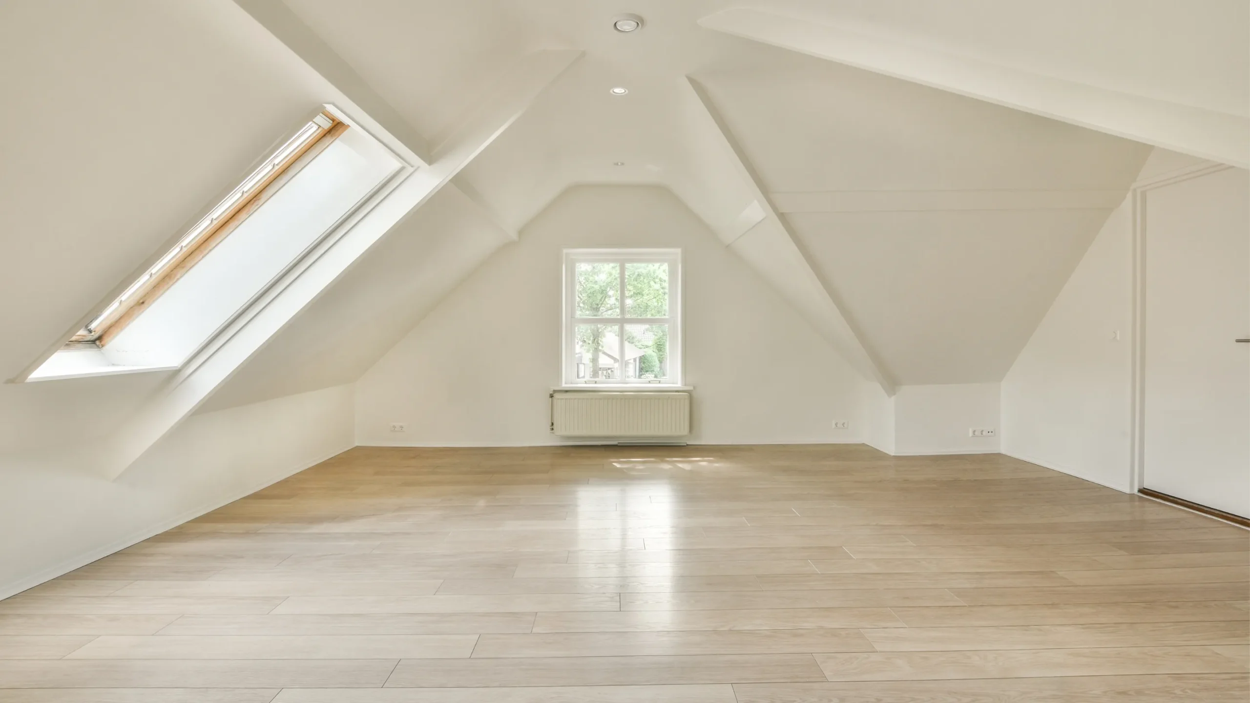 white attic converted with dormer windows and wood flooring